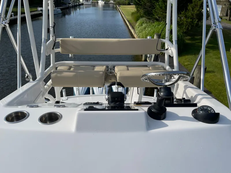 Slide: The Image of 2019 Everglades 435 CC boat helm with seating, cup holders, and controls on a canal. - 18