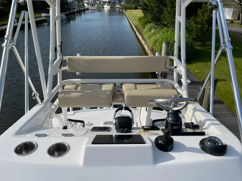 Slide: The Image of 2019 Everglades 435 CC boat helm with seating, overlooking a serene canal. - 19