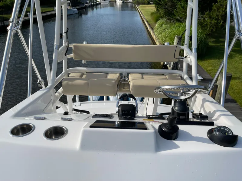 Slide: The Image of 2019 Everglades 435 CC boat helm with seating, overlooking a serene canal. - 20