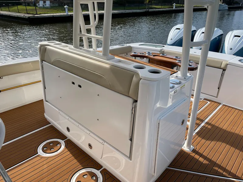 Slide: The Image of 2019 Everglades 435 CC boat interior with teak flooring and seating by the water. - 22