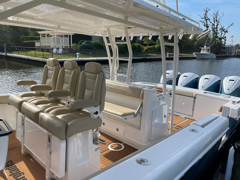 Slide: The Image of 2019 Everglades 435 CC boat with luxurious seating and multiple engines docked by the water. - 25