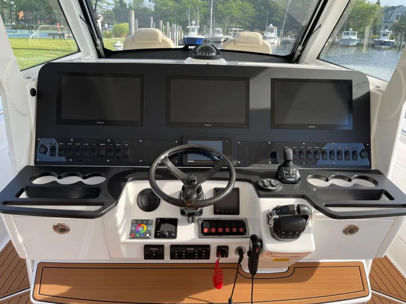 Slide: The Image of Control panel of 2019 Everglades 435 CC boat with multiple screens and steering wheel. - 28