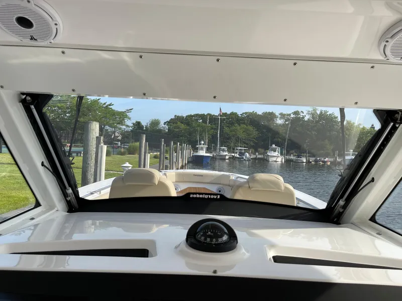 Slide: The Image of 2019 Everglades 435 CC boat interior view with compass, docked at marina. - 35