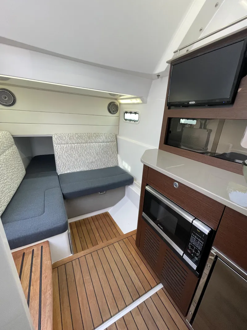 Slide: The Image of 2019 Everglades 435 CC cabin interior with seating, kitchenette, and wood flooring. - 39