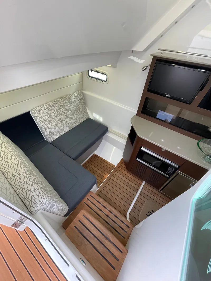 Slide: The Image of 2019 Everglades 435 CC cabin interior with seating, TV, and kitchenette. - 40