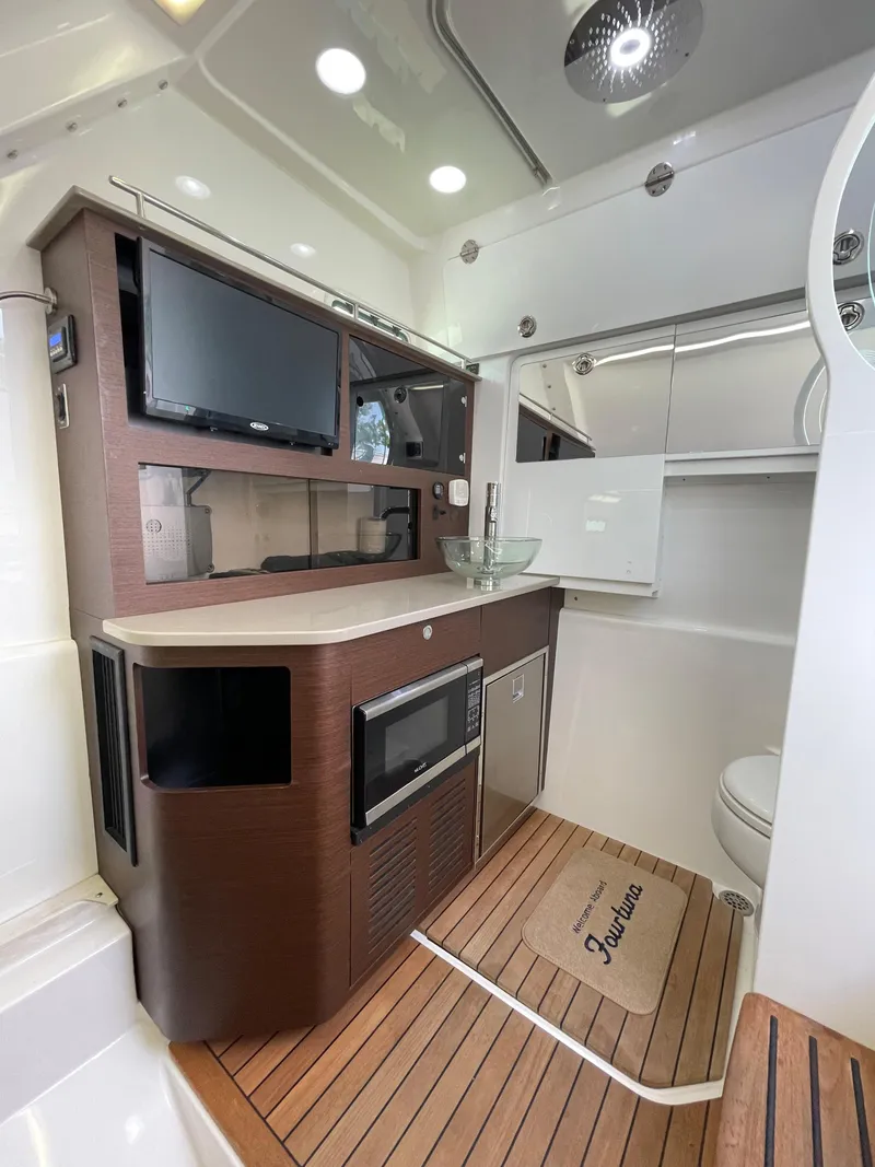 Slide: The Image of 2019 Everglades 435 CC cabin interior with modern amenities and wooden flooring. - 41