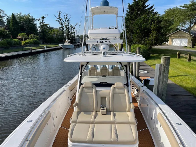 Slide: The Image of 2019 Everglades 435 CC boat docked by a scenic canal with lush greenery. - 44