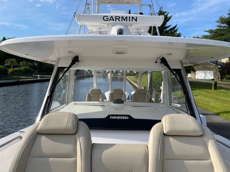 Slide: The Image of 2019 Everglades 435 CC boat with Garmin equipment, docked by a canal. - 49