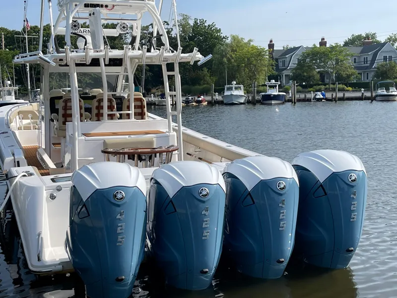 Slide: The Image of 2019 Everglades 435 CC boat with four Yamaha outboard engines docked by waterfront homes. - 5