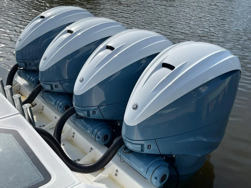 Slide: The Image of Four powerful outboard motors on a 2019 Everglades 435 CC boat, docked on water. - 7