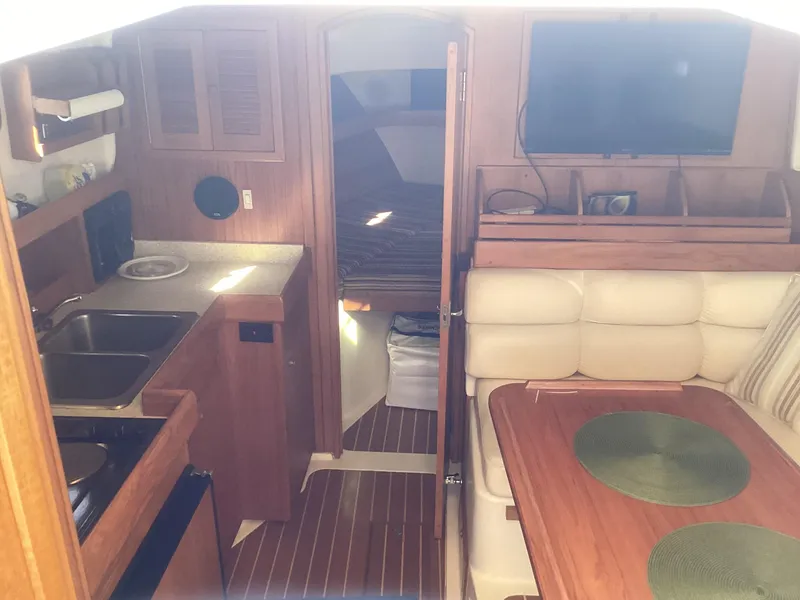 Slide: The Image of Interior of 2002 Mainship 34 PILOT boat with kitchen and dining area. - 10