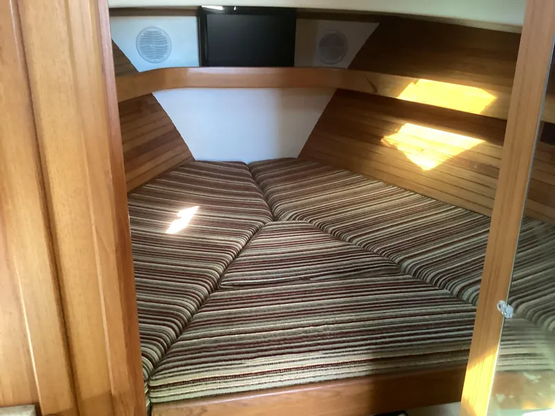 Slide: The Image of Cozy cabin interior of 2002 Mainship 34 PILOT with striped cushions and wood paneling. - 12