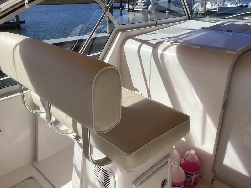 Slide: The Image of Interior of 2002 Mainship 34 PILOT boat with beige seating and marina view. - 13
