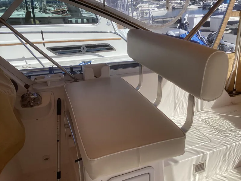 Slide: The Image of 2002 Mainship 34 PILOT interior with white seating and helm area. - 14