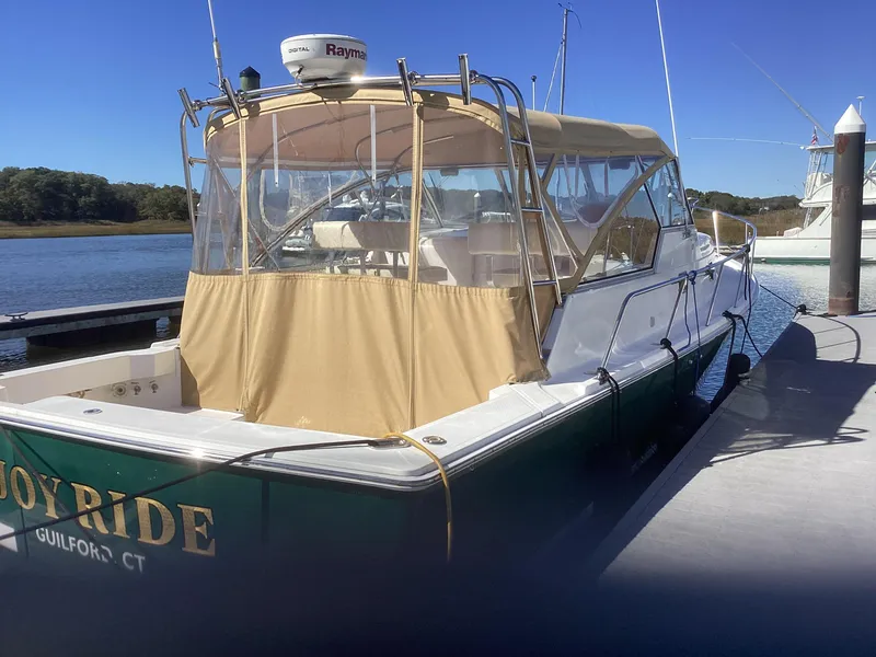 Slide: The Image of 2002 Mainship 34 PILOT boat docked with tan canopy and green hull. - 3