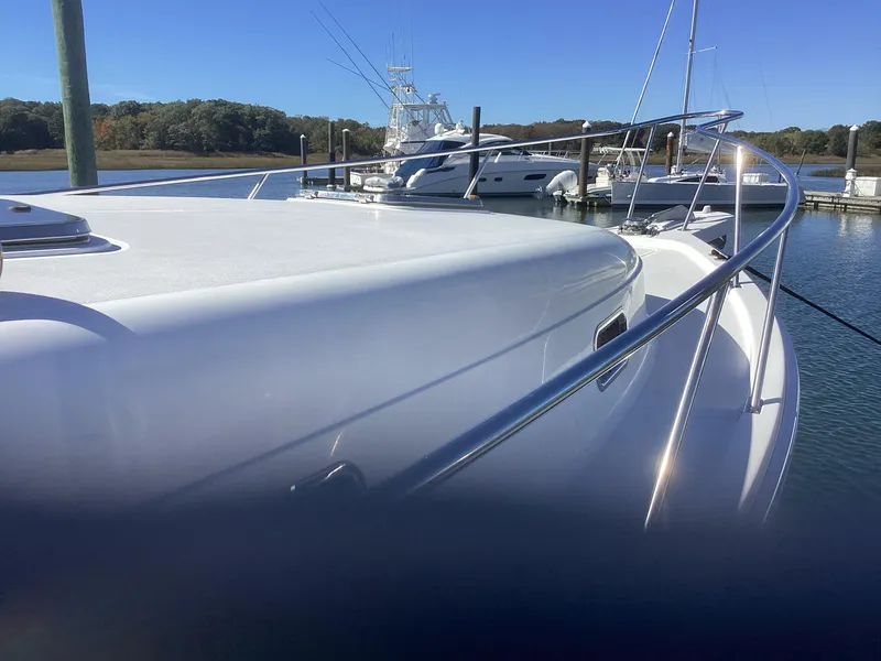Slide: The Image of 2002 Mainship 34 PILOT yacht docked in a marina under clear blue skies. - 6