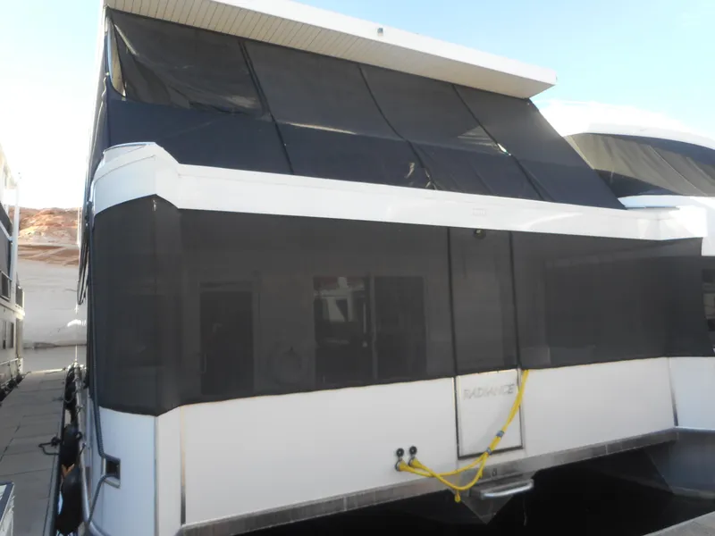 Slide: The Image of Adonia Radiance Share #12 houseboat, 2022 model, docked with black mesh coverings. - 1