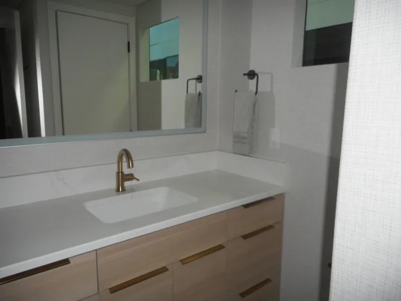 Slide: The Image of Modern bathroom with light wood vanity, gold faucet, and large mirror, Adonia Radiance Share #12. - 17