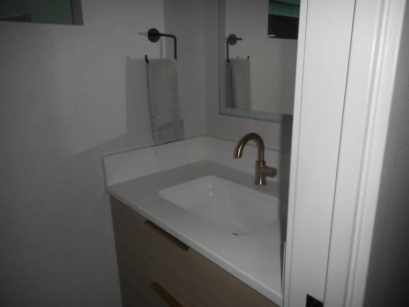 Slide: The Image of Modern bathroom with white sink, gold faucet, and towel rack. Adonia Radiance Share #12, 2022. - 20