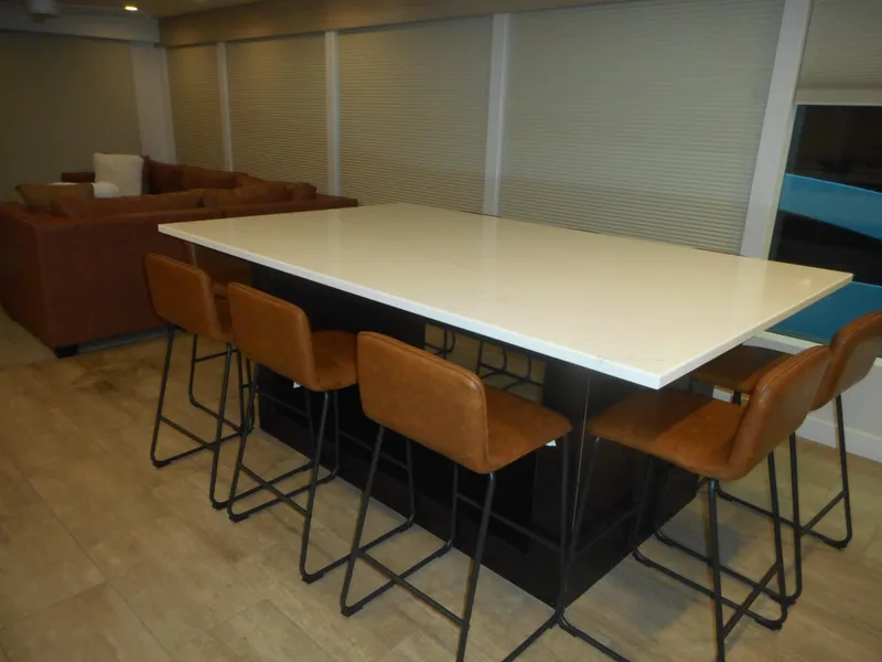 Slide: The Image of Modern dining area with white table, brown chairs, and a cozy sofa in a stylish room. - 37