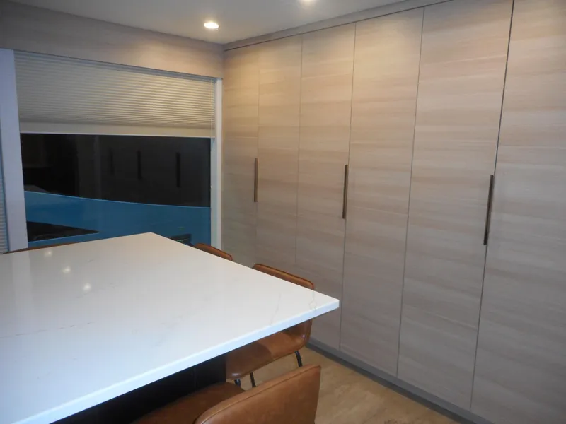 Slide: The Image of Modern kitchen with sleek cabinets, white countertop, and brown chairs, Adonia Radiance Share #12, 2022. - 38