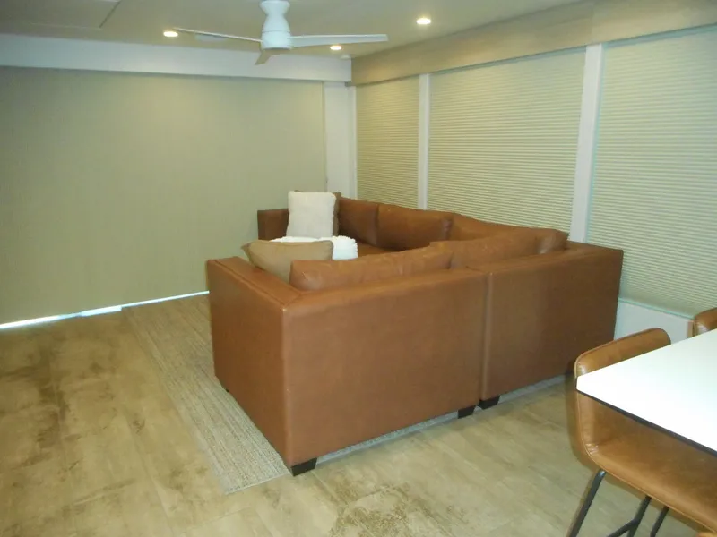 Slide: The Image of Modern living room with brown sectional sofa, white ceiling fan, and wooden flooring. Adonia Radiance Share #12, 2022. - 39