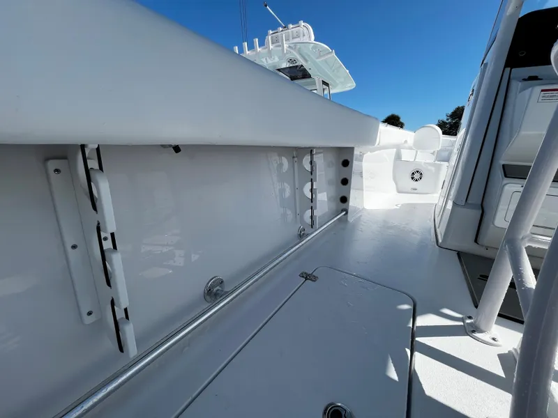 Slide: The Image of 2024 Sportsman Open 252 Center Console boat deck with rod holders and storage compartments. - 10