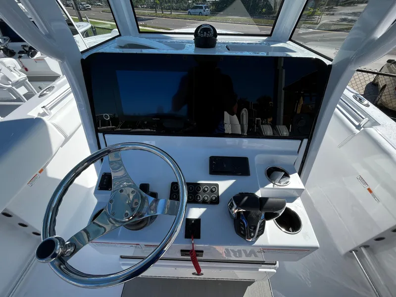 Slide: The Image of 2024 Sportsman Open 252 Center Console boat helm with steering wheel and controls. - 13