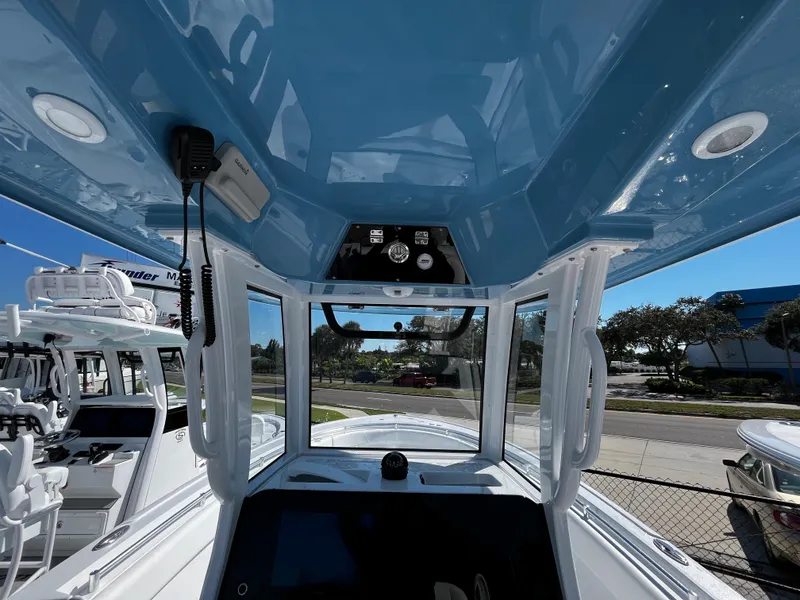 Slide: The Image of 2024 Sportsman Open 252 Center Console boat interior with blue T-top and control panel. - 14
