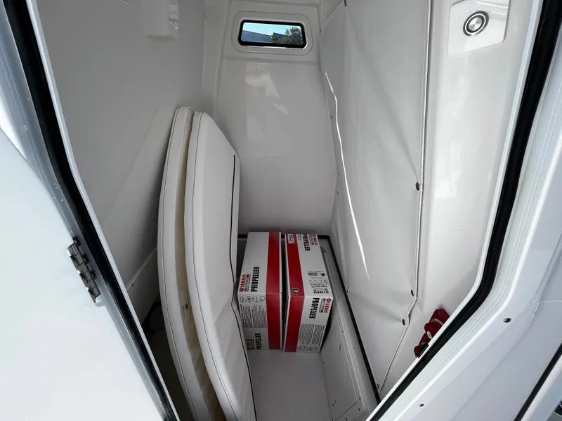 Slide: The Image of 2024 Sportsman Open 252 Center Console storage compartment with cushions and supplies. - 16
