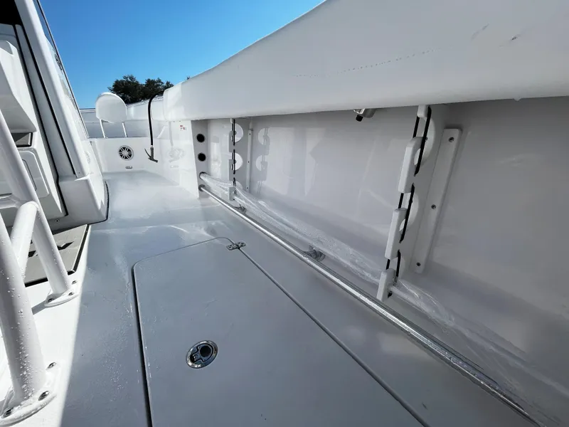 Slide: The Image of 2024 Sportsman Open 252 Center Console boat interior, featuring sleek white deck and storage compartments. - 9