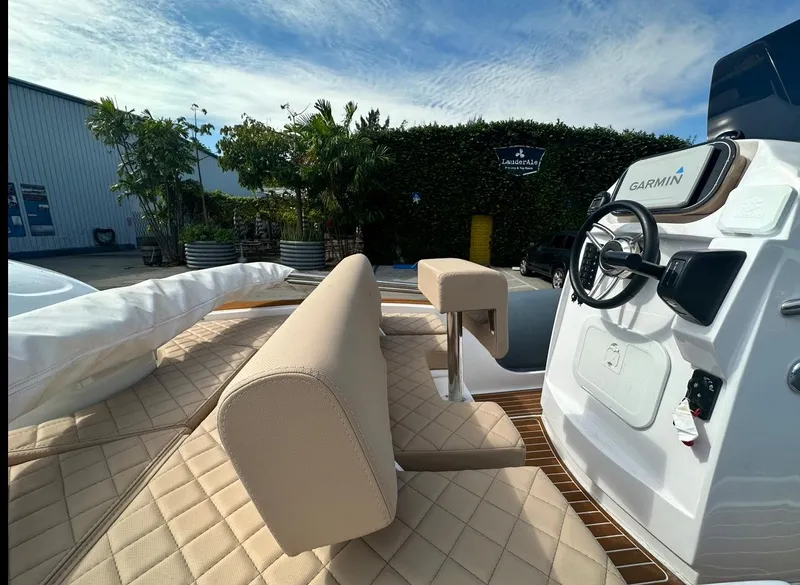 Slide: The Image of 2023 2 Bar 6.20 boat interior with beige seating and Garmin navigation system. - 6