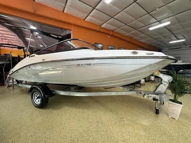 Slide: The Image of 2024 Yamaha Boats SX195 on trailer, towed by a tractor. - 1