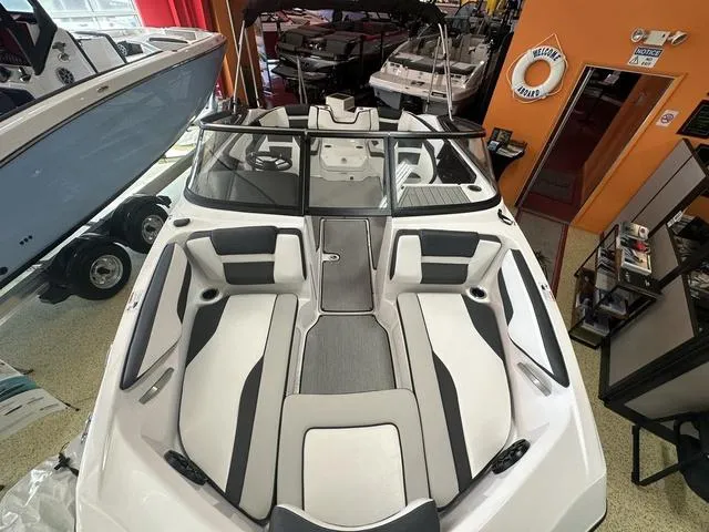 Slide: The Image of 2024 Yamaha Boats SX195, sleek white and gray interior, spacious seating arrangement. - 2