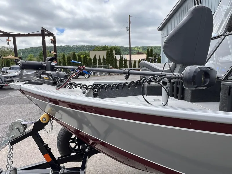 Slide: The Image of 2024 Starcraft Renegade 168 DC boat with Minn Kota motor, parked outdoors. - 11