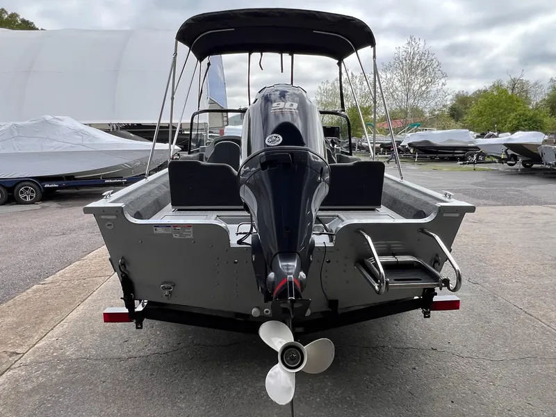 Slide: The Image of 2024 Starcraft Renegade 168 DC boat with outboard motor, parked outdoors. - 19