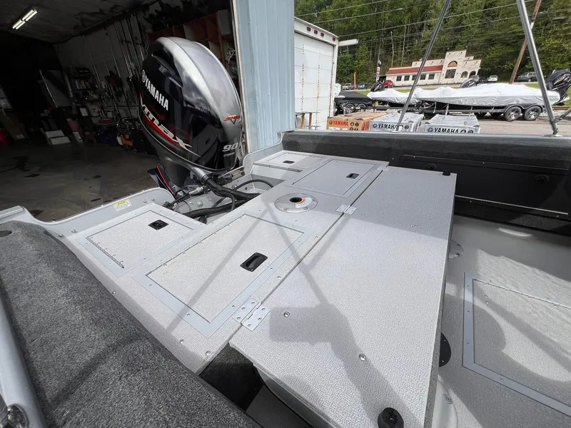 Slide: The Image of 2024 Starcraft Renegade 168 DC boat interior with Yamaha outboard motor in a garage setting. - 27