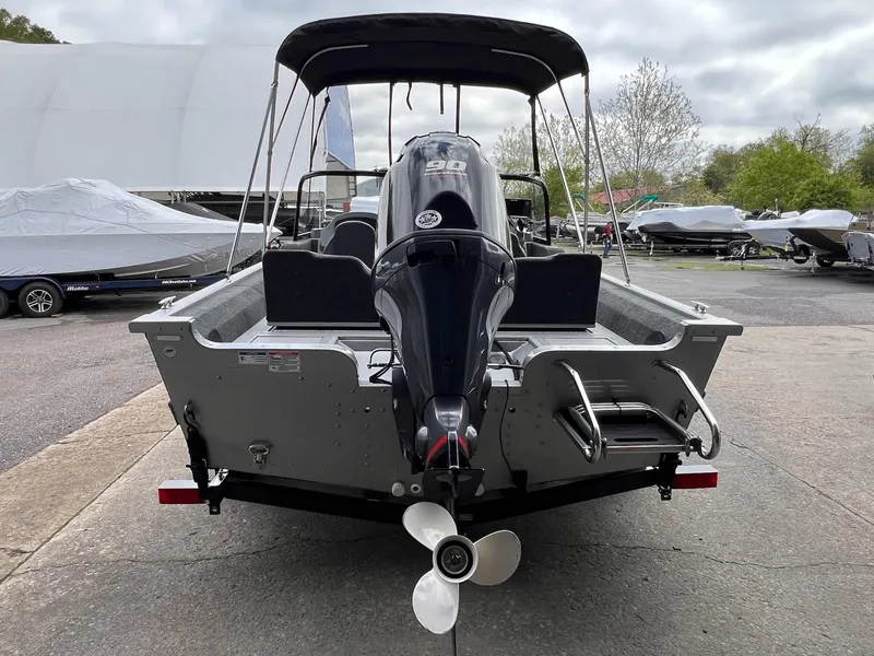 Slide: The Image of 2024 Starcraft Renegade 168 DC boat with outboard motor, parked outdoors. - 3