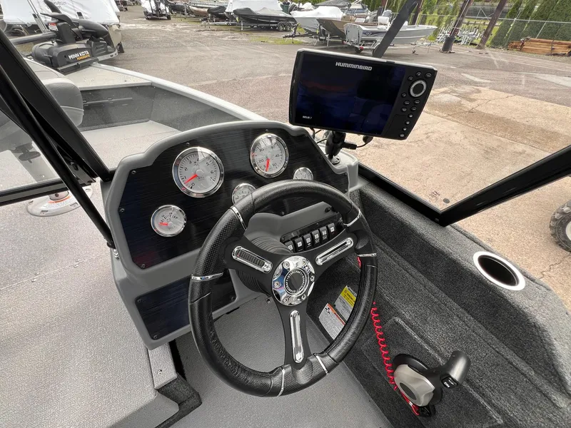 Slide: The Image of 2024 Starcraft Renegade 168 DC boat dashboard with steering wheel and Humminbird fish finder. - 30