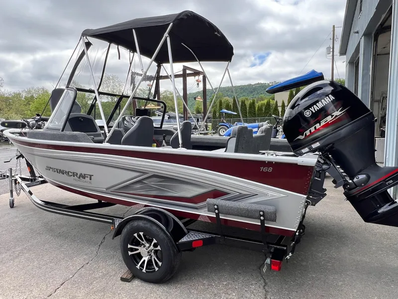 Slide: The Image of 2024 Starcraft Renegade 168 DC boat with Yamaha engine, parked outdoors. - 31