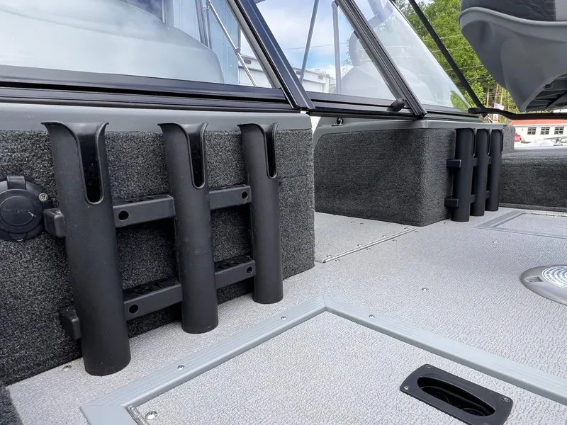 Slide: The Image of 2024 Starcraft Renegade 168 DC boat interior with rod holders and carpeted flooring. - 4