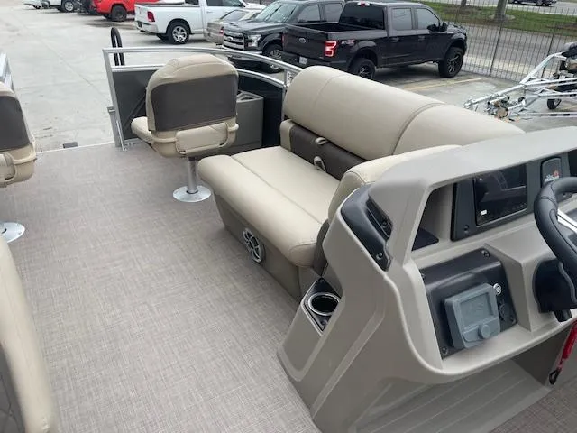 Slide: The Image of 2024 Sun Tracker Fishin' Barge 20 DLX interior with beige seating and control console. - 11