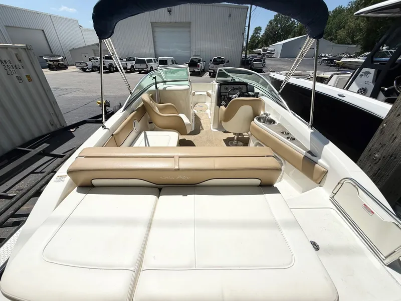 Slide: The Image of 2011 Sea Ray 240 Sundeck boat interior with seating and helm, parked outdoors. - 4