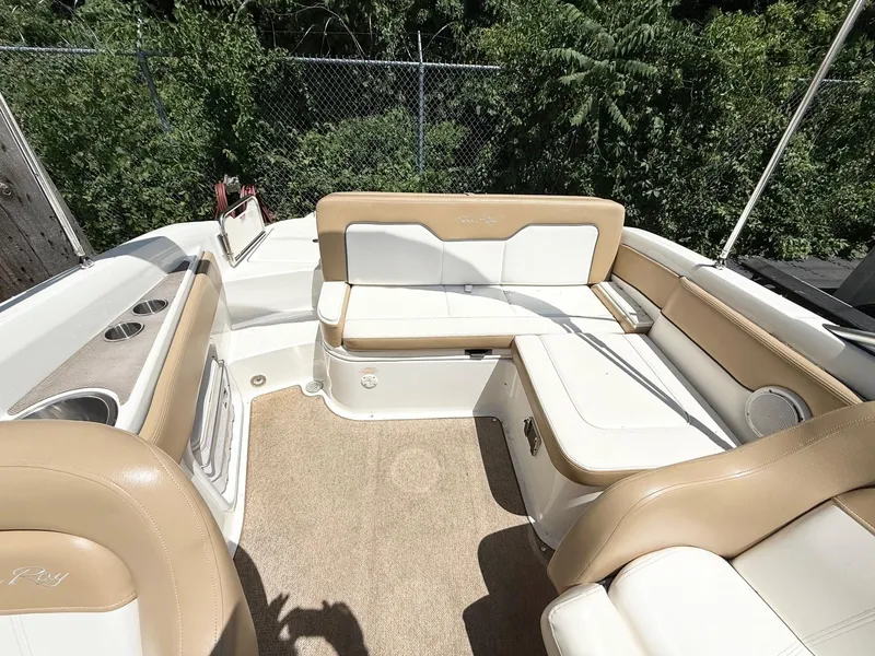 Slide: The Image of 2011 Sea Ray 240 Sundeck interior with beige seating and cup holders. - 5
