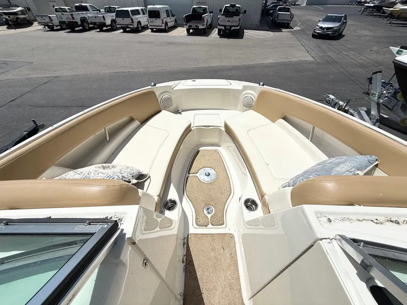Slide: The Image of 2011 Sea Ray 240 Sundeck boat interior with beige seating and carpeted floor. - 8