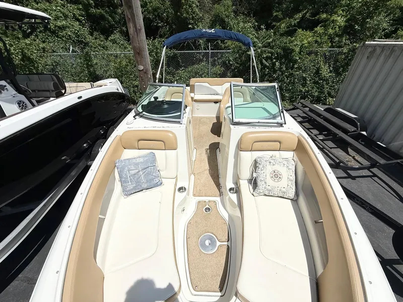 Slide: The Image of 2011 Sea Ray 240 Sundeck boat with beige seating and blue canopy, docked outdoors. - 9