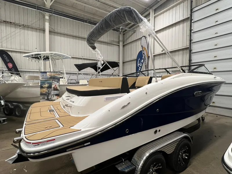 Slide: The Image of 2024 Sea Ray SPX 210 boat on trailer in indoor showroom. - 2