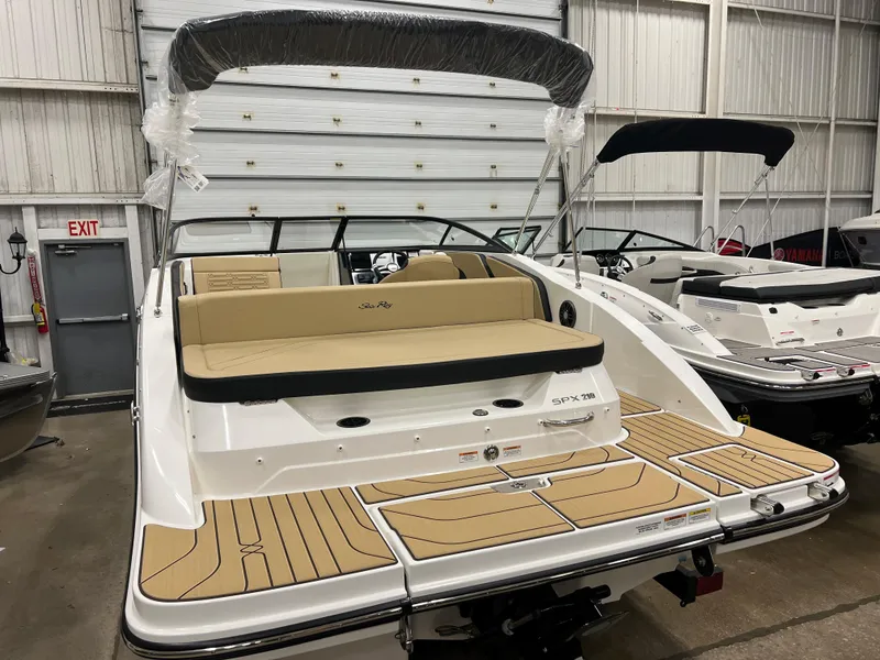 Slide: The Image of 2024 Sea Ray SPX 210 boat with tan seating and swim platform in a showroom. - 3