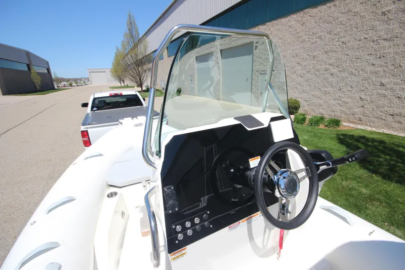 Slide: The Image of 2025 Zodiac Medline 5.8 NEO boat with steering console, parked near a building. - 20