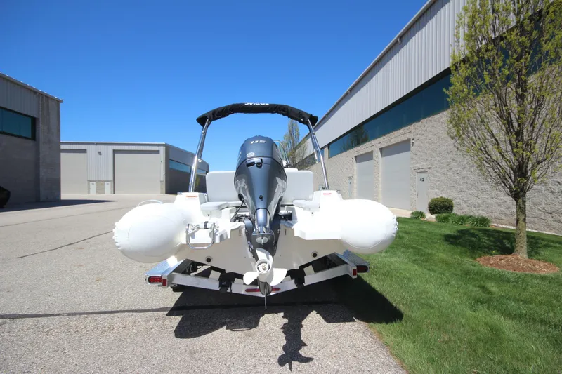 Slide: The Image of 2025 Zodiac Medline 5.8 NEO boat with 115hp engine on trailer, parked outdoors. - 3